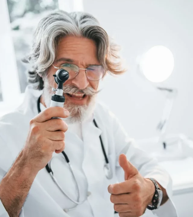 Doctor holding an ophthalmoscope during a window tint medical exemption consultation